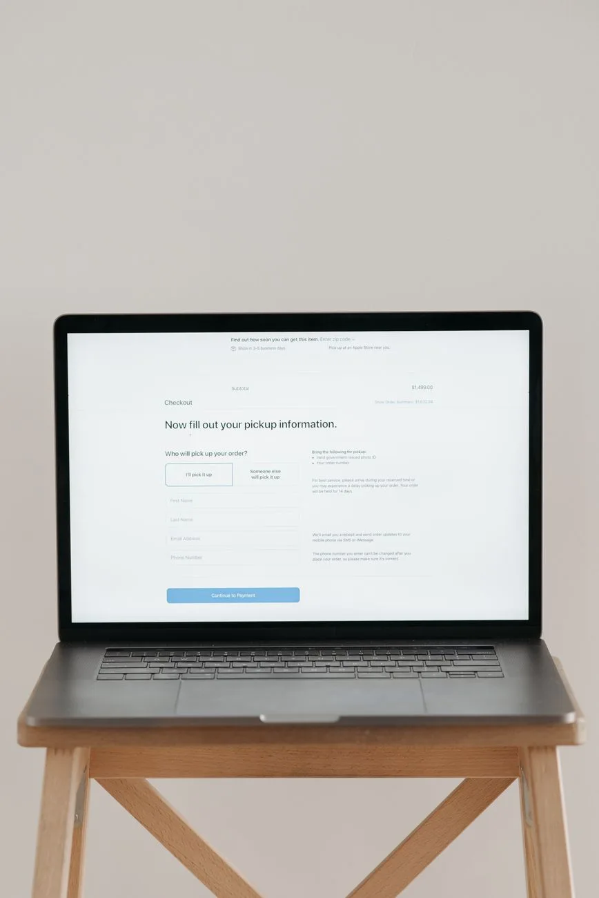 A laptop on a desk displaying an online checkout form.