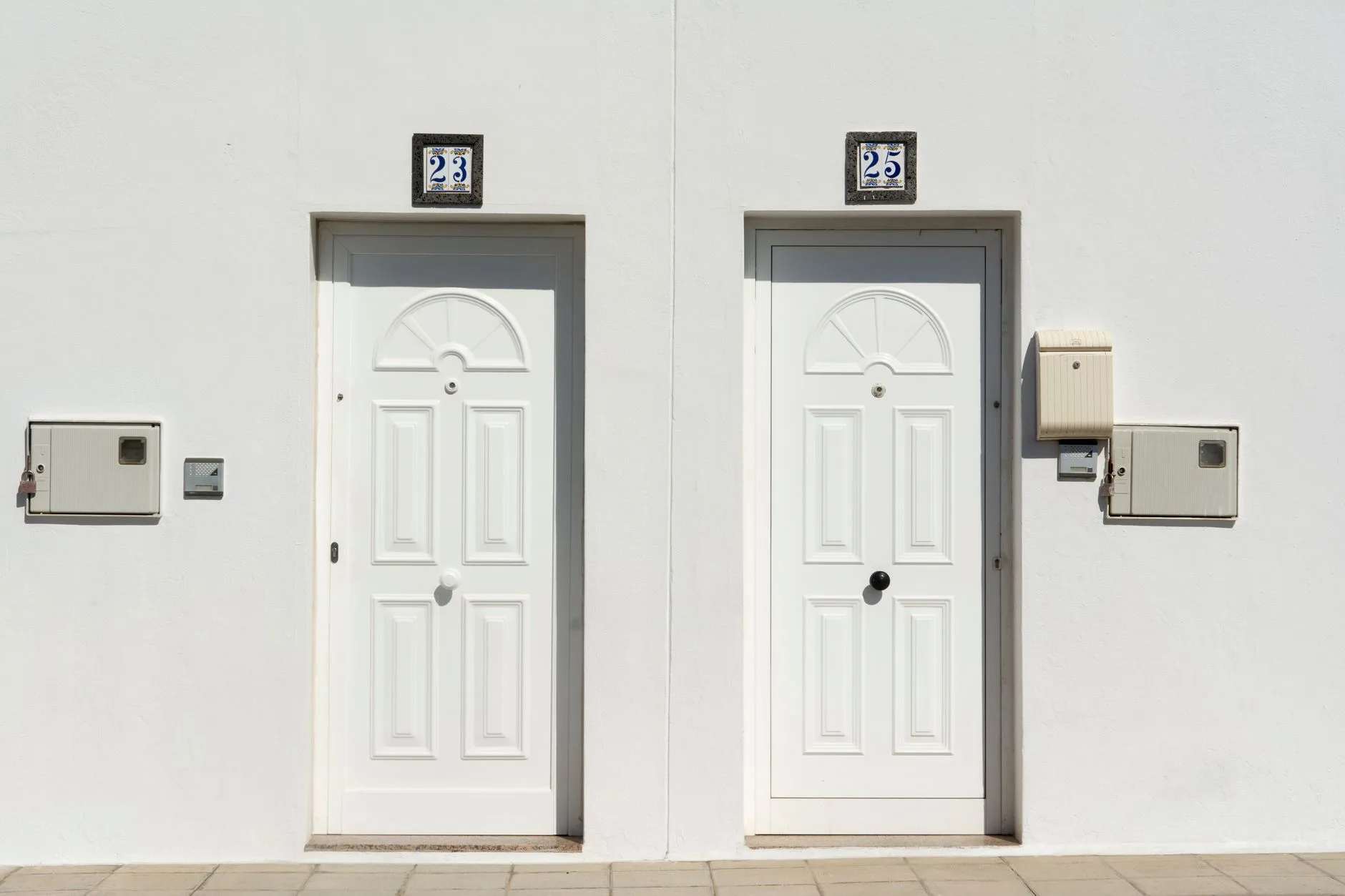 Two apartment doors side by side, each marked with its own unit number.