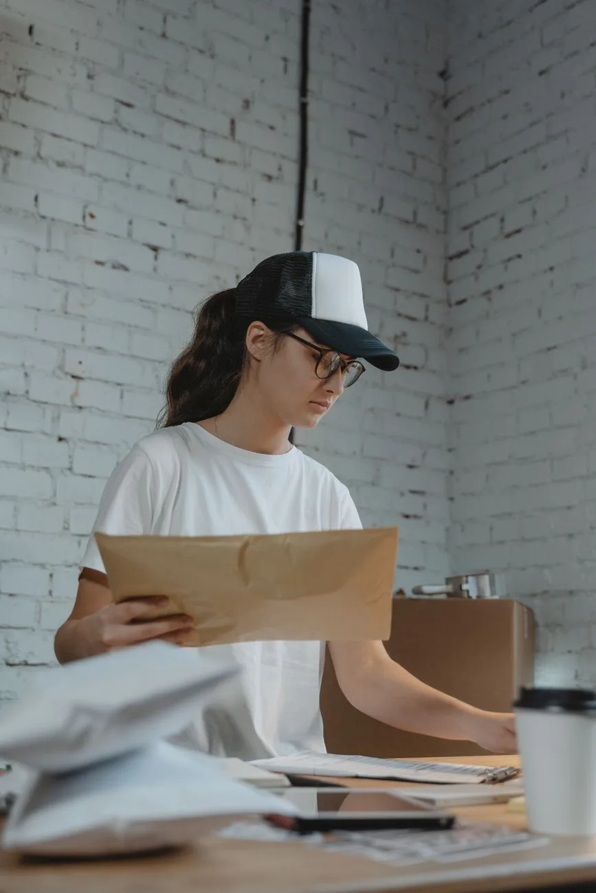 An office worker sorting parcels and mail in a modern workspace.