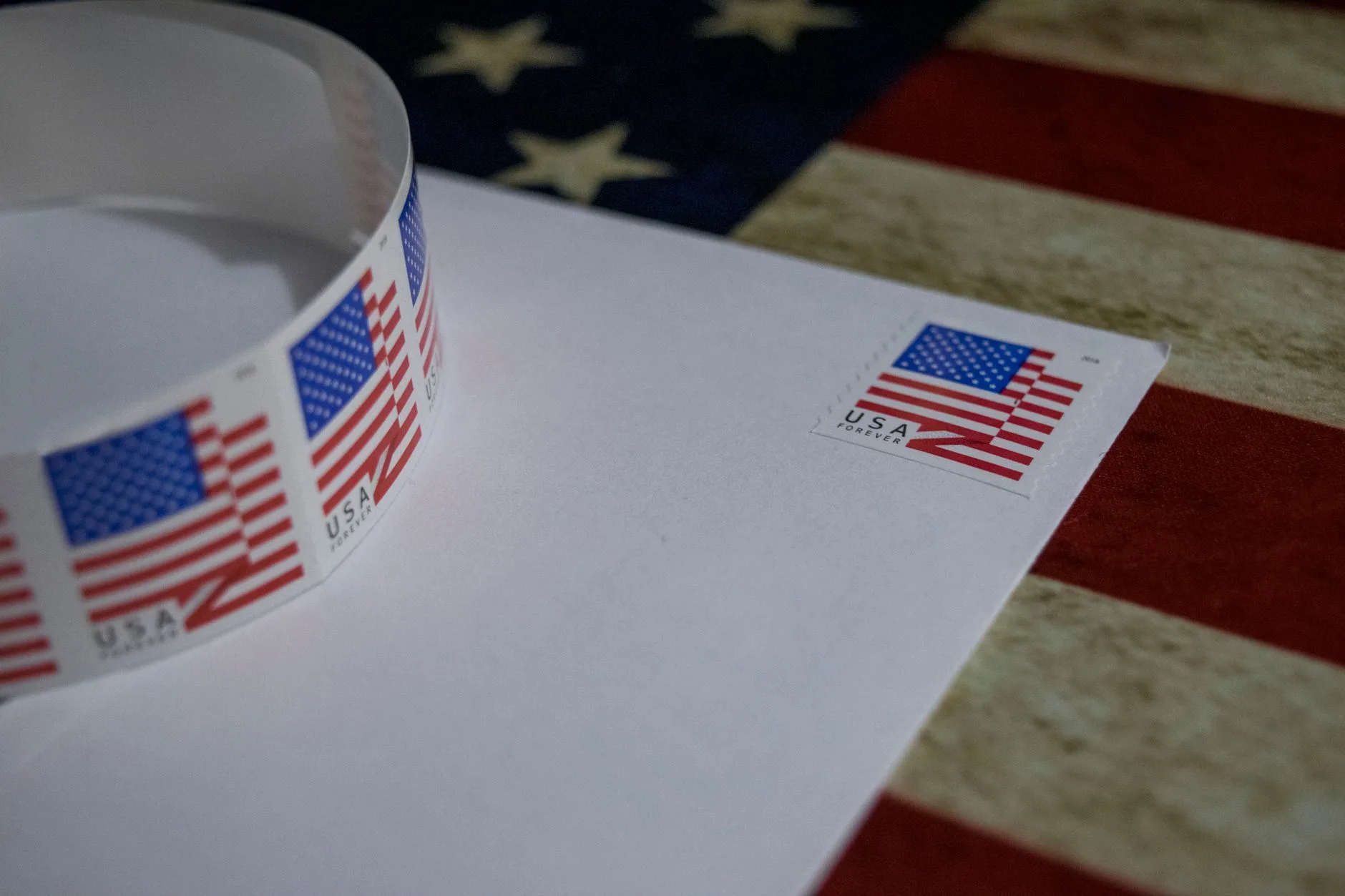 A close-up of a USA flag postage stamp on a white envelope.