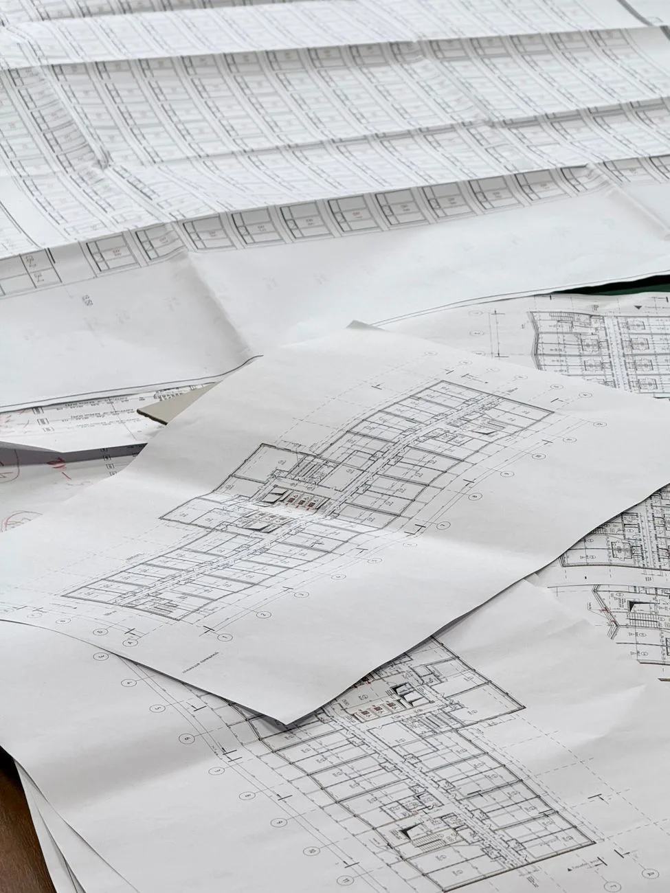 Detailed architectural blueprints spread out on a desk.