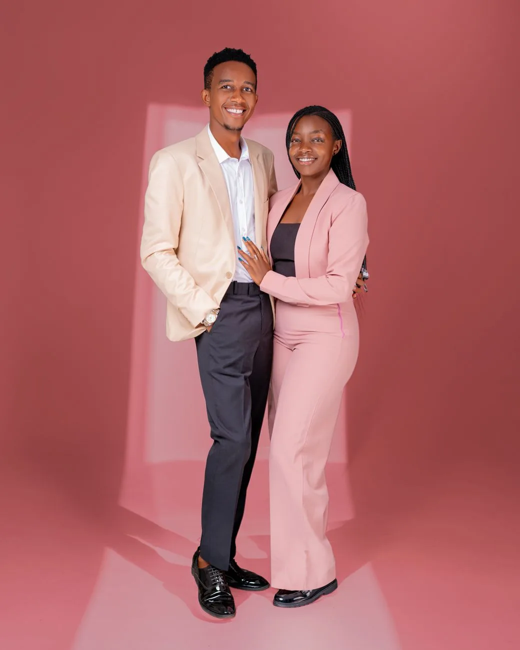 A professional couple posing confidently in color-coordinated suits.