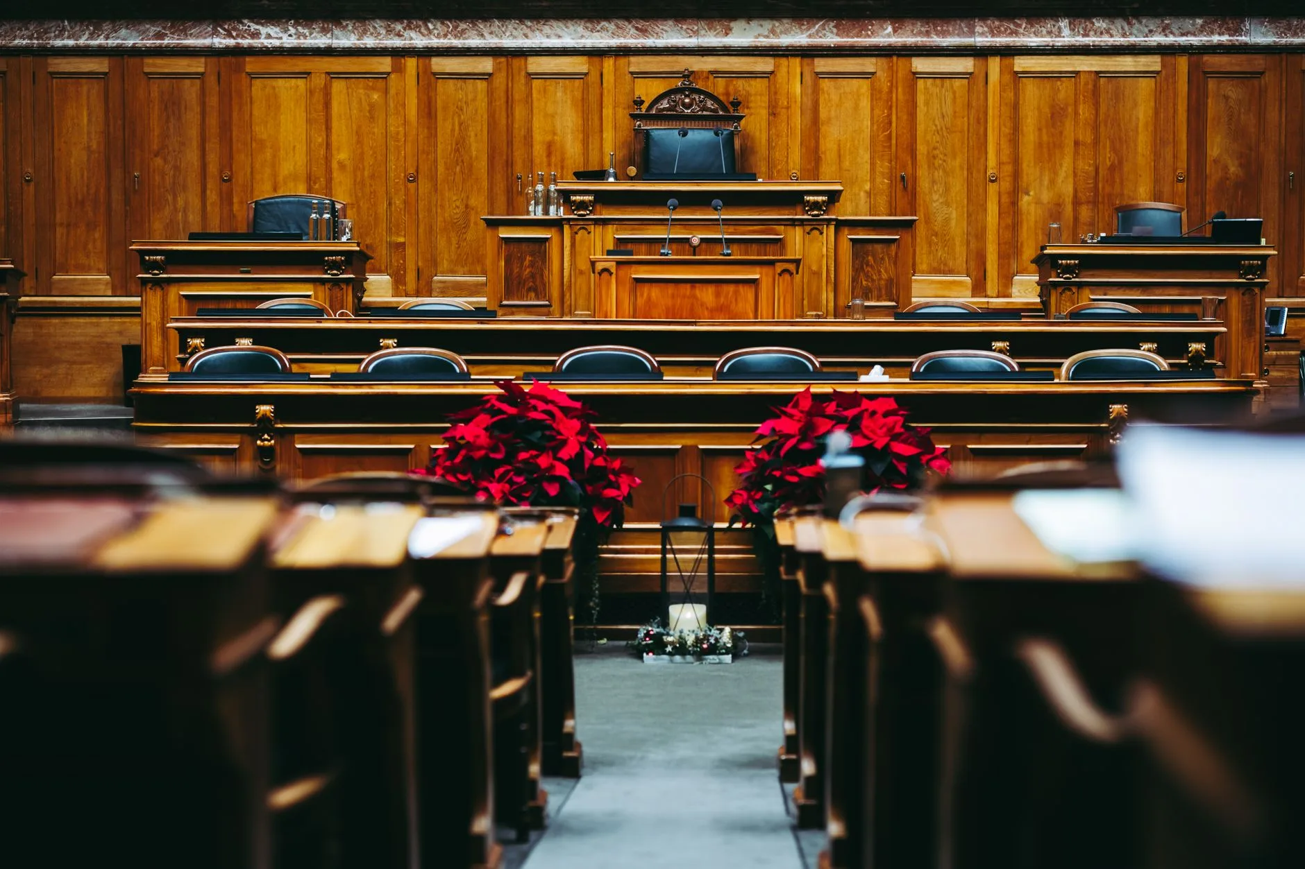 A spacious, elegant wooden courtroom with empty seats.
