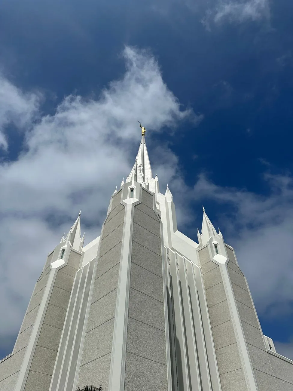 The dramatic architecture of a white LDS temple against a blue sky.