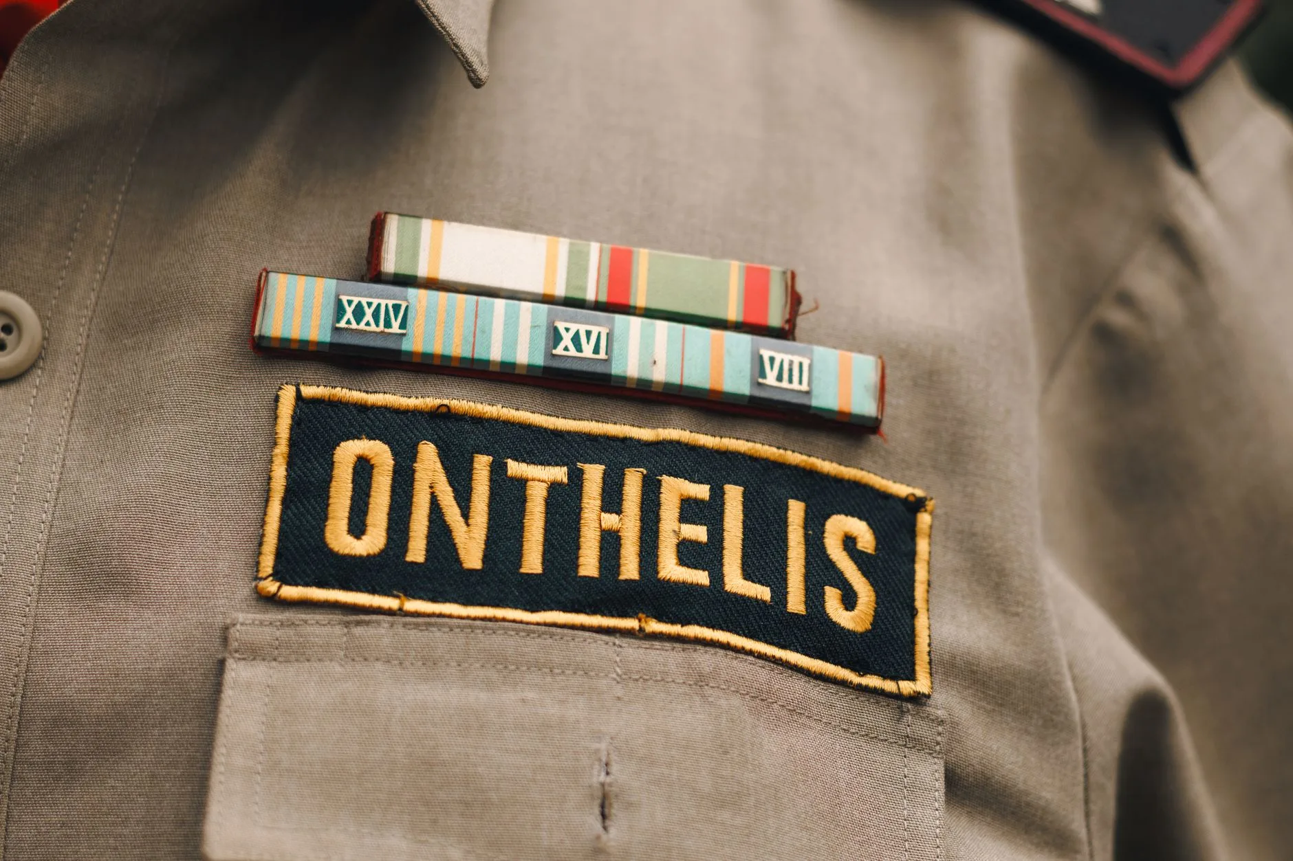 A close-up of a military uniform name tag and service ribbons.