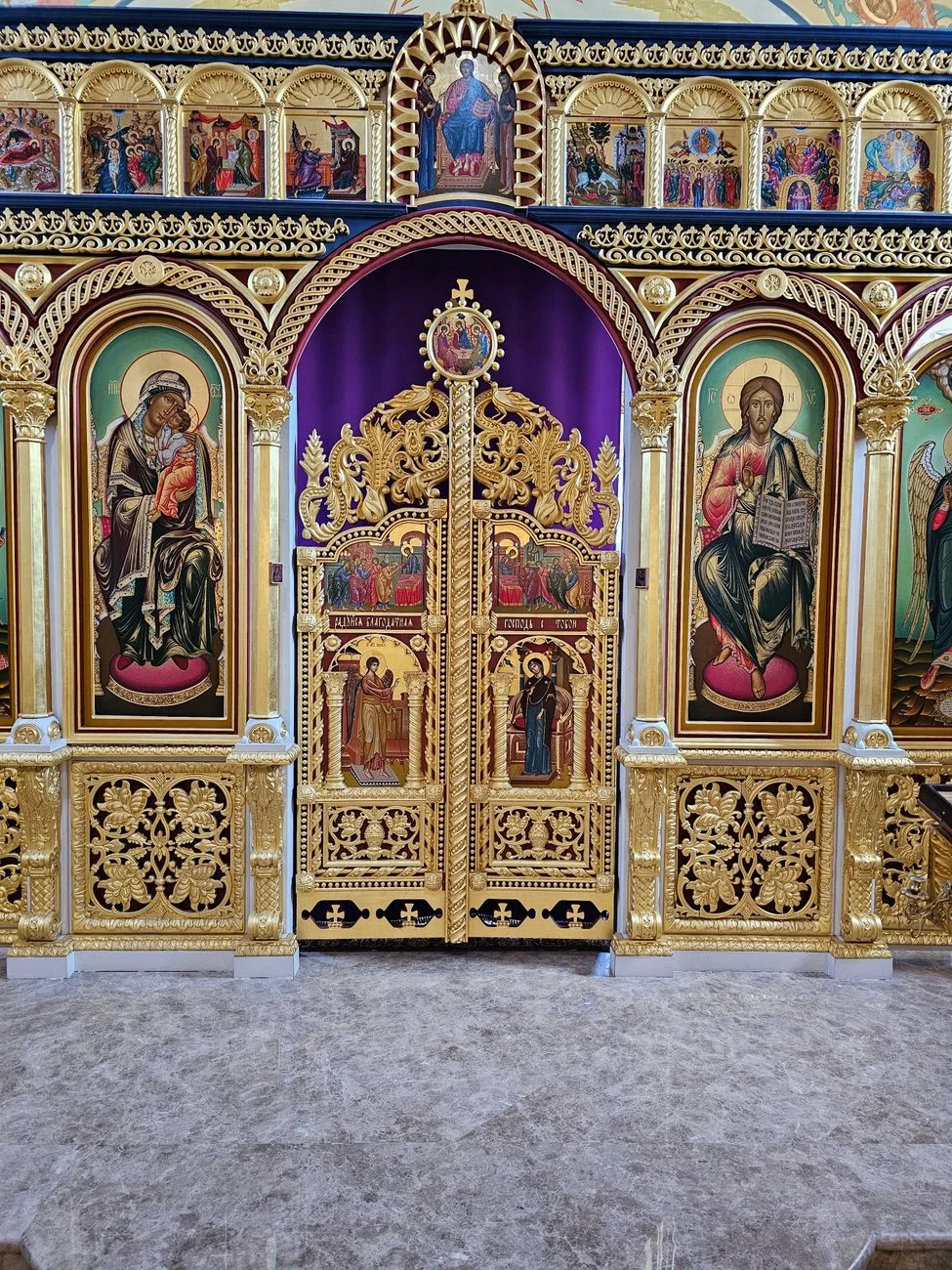 A detailed Byzantine iconostasis with religious icons and gold embellishments.