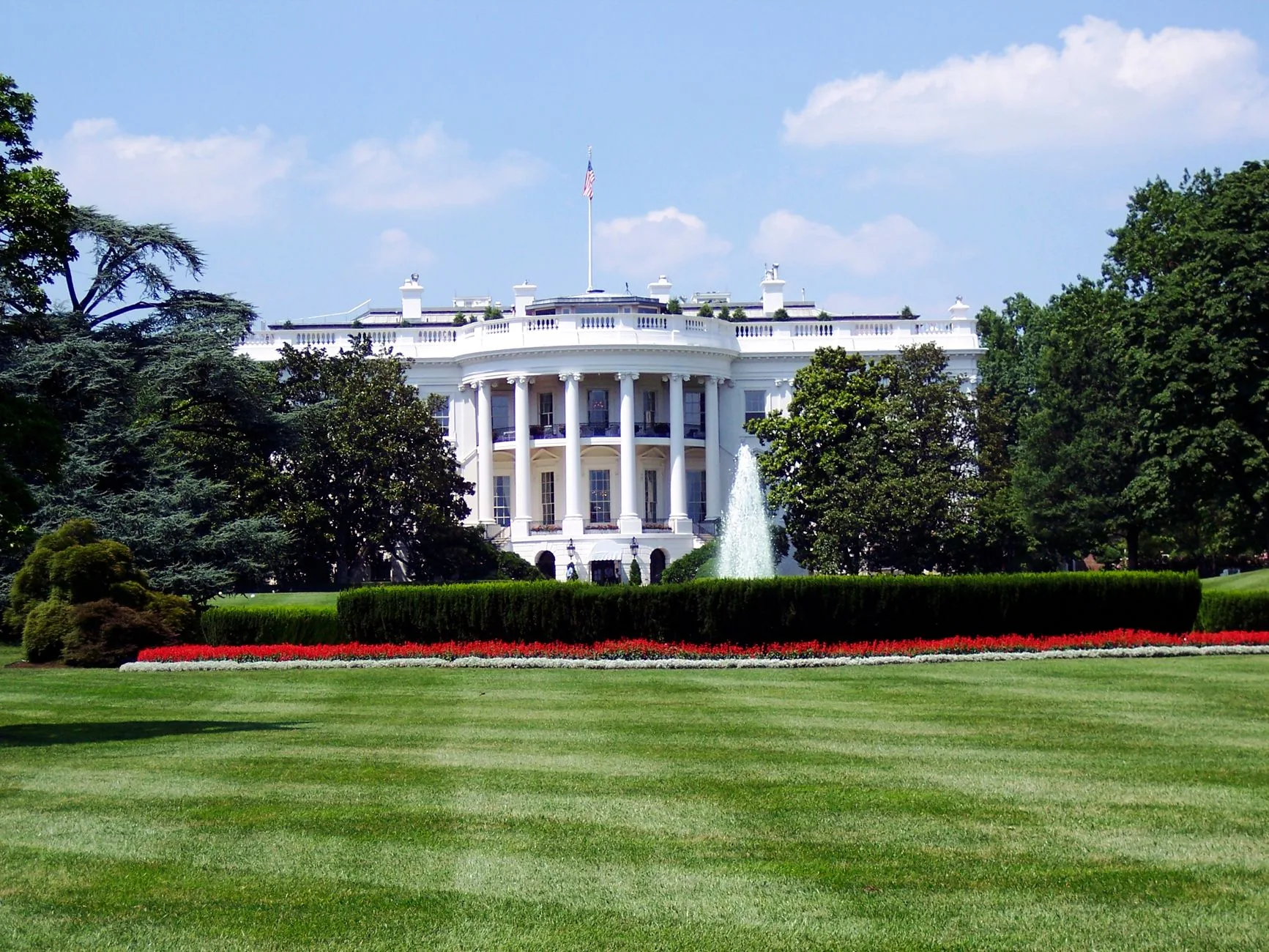The White House exterior with lawn and fountain on a sunny day.