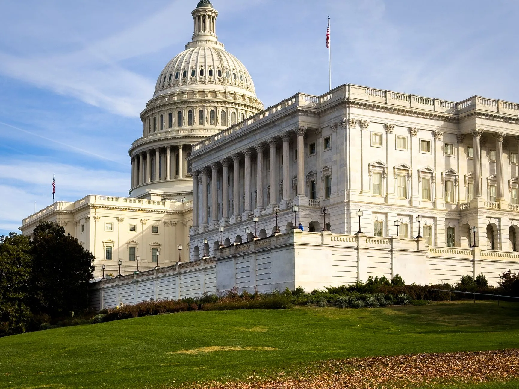 A picturesque corner view of the US Capitol Building under a clear sky.