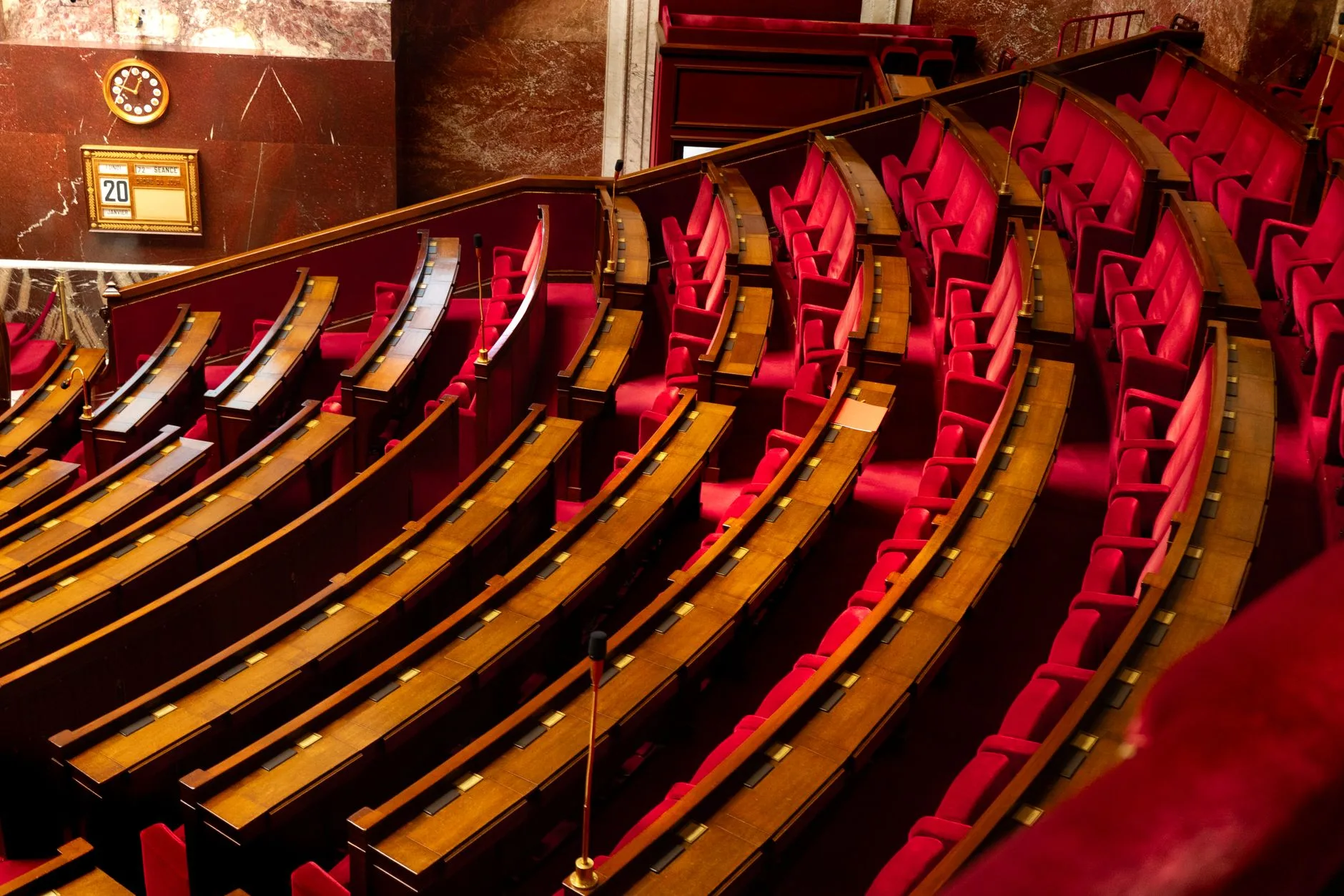 An elegant legislative chamber with curved seating and wooden desks.