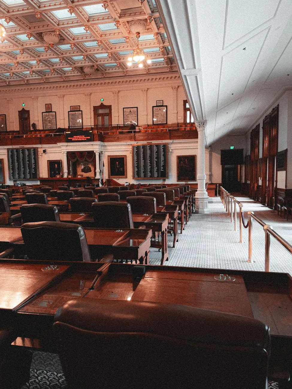 The classic interior of a legislative chamber with rows of seating.