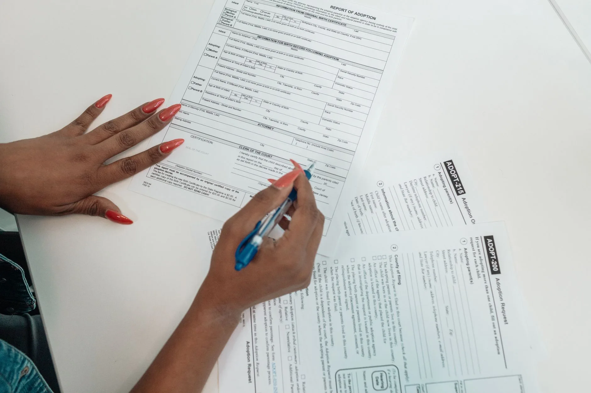 A person filling out an application form by hand at a desk.