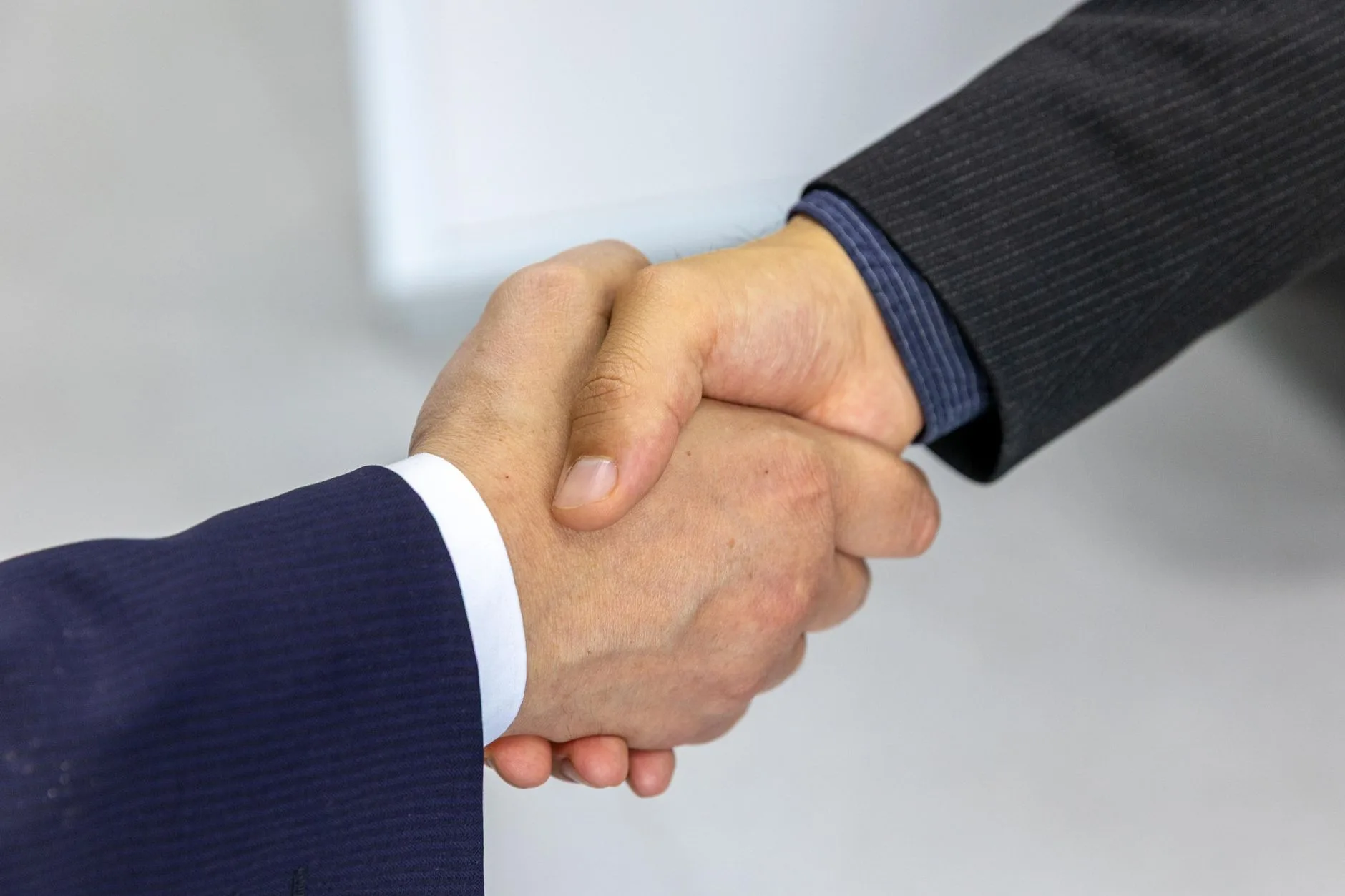 Two people shaking hands in a formal, professional setting.