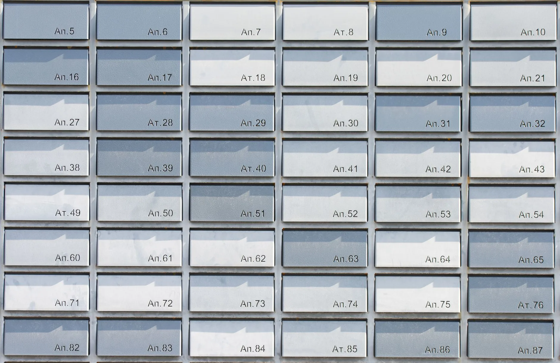 Rows of metallic apartment mailboxes arranged in a symmetrical grid.
