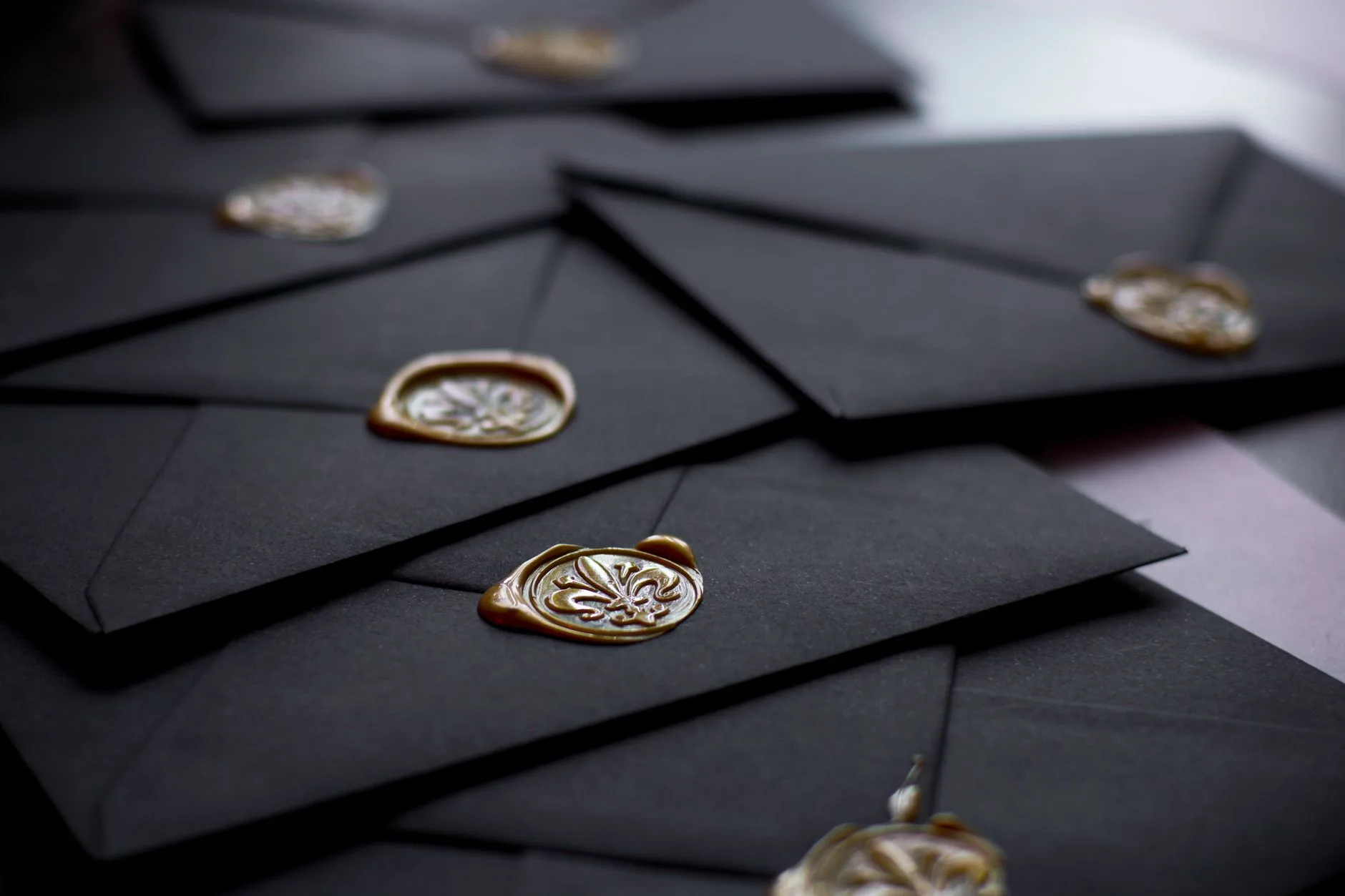 A close-up of black envelopes featuring vintage wax seals.