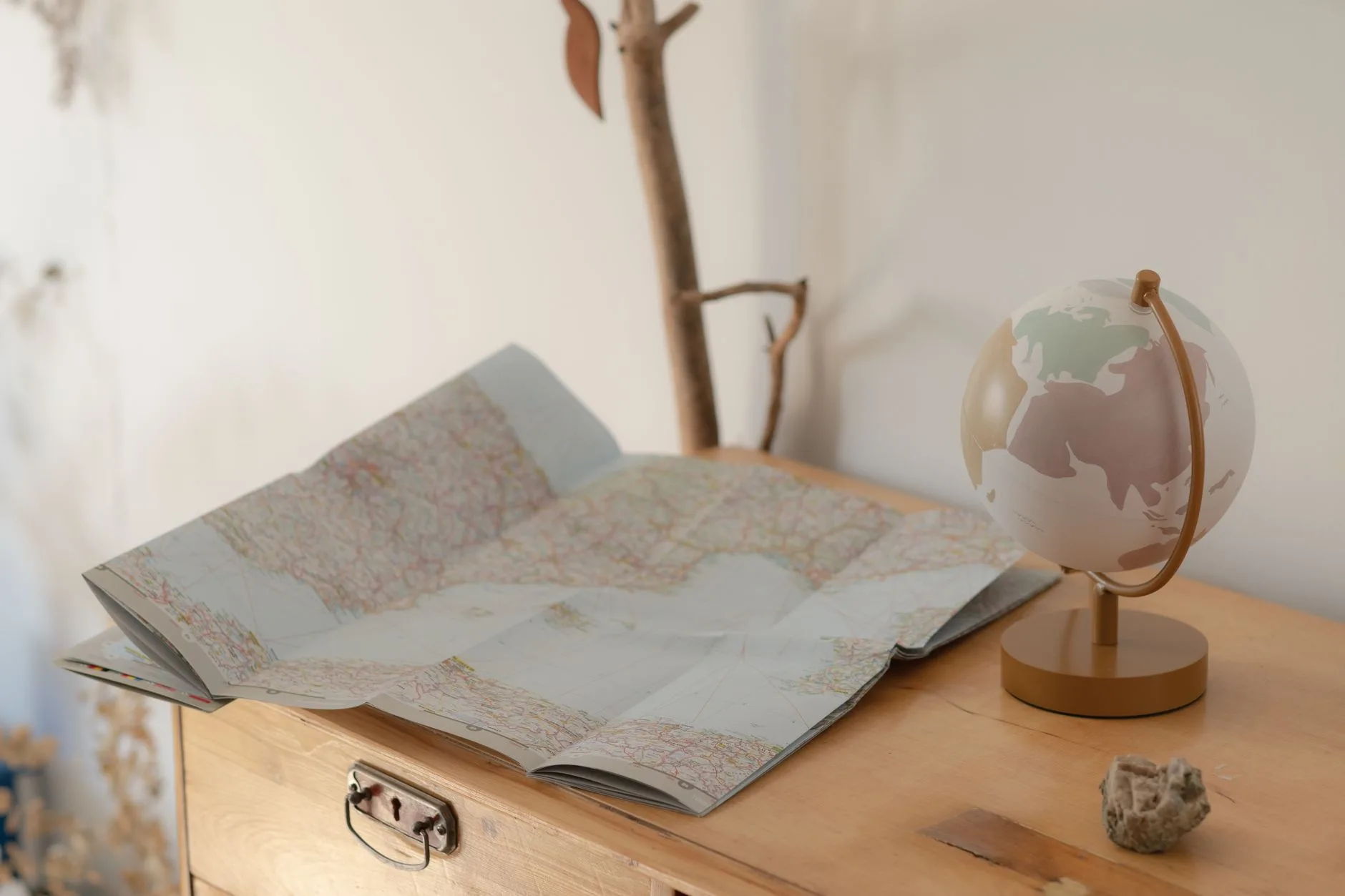 A vintage map and globe on a wooden table.