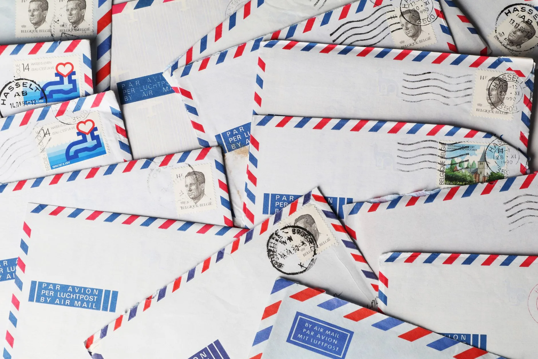 A close-up of vintage airmail envelopes with stamps and postmarks.