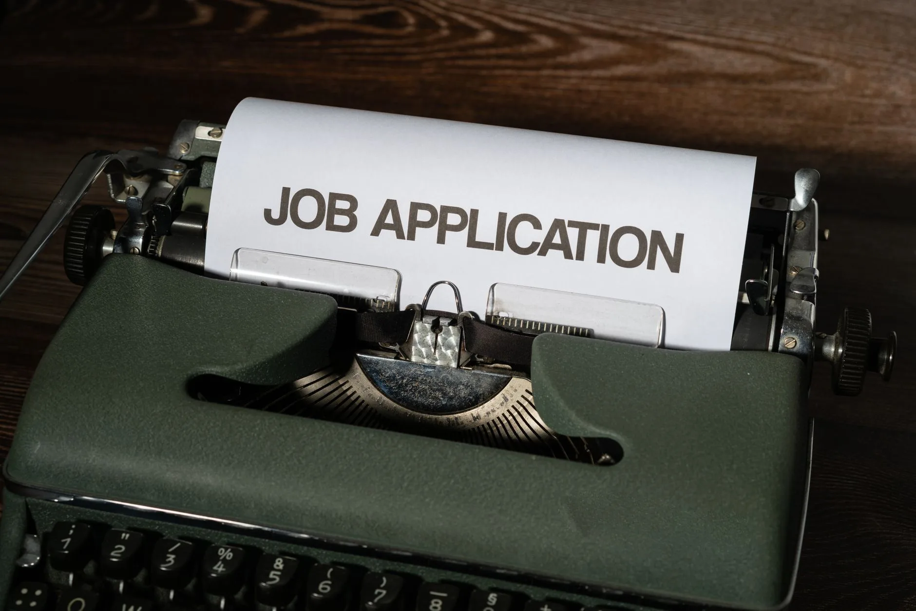 A close-up of a vintage typewriter with a job application inserted.