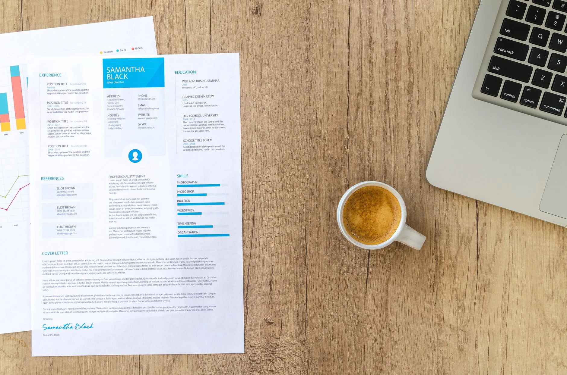 A top view of a desk with a resume, coffee cup, and laptop.
