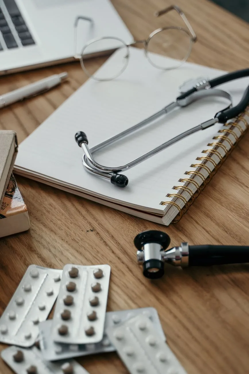 A stethoscope and notebook on a doctor's desk.