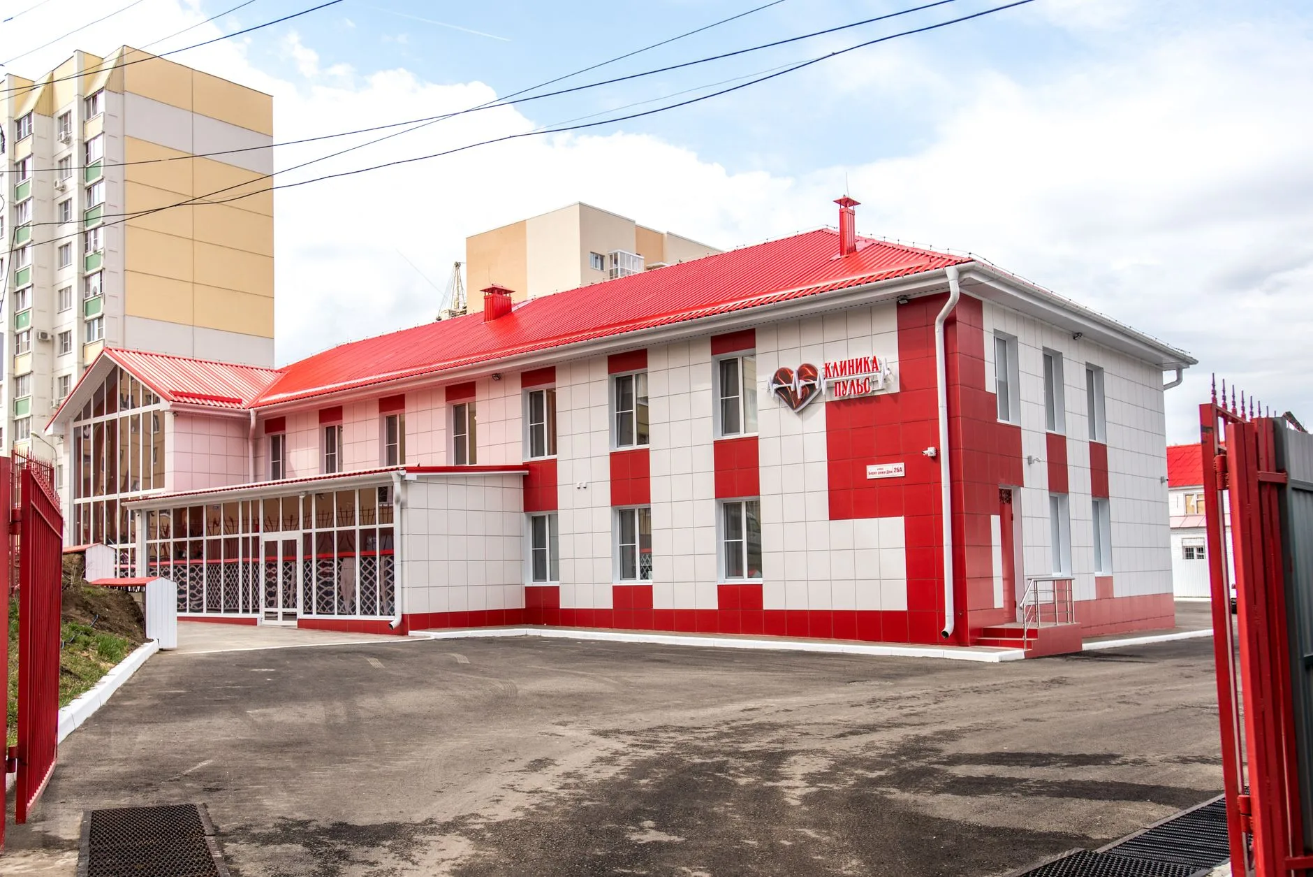 A modern clinic building with a red and white facade.
