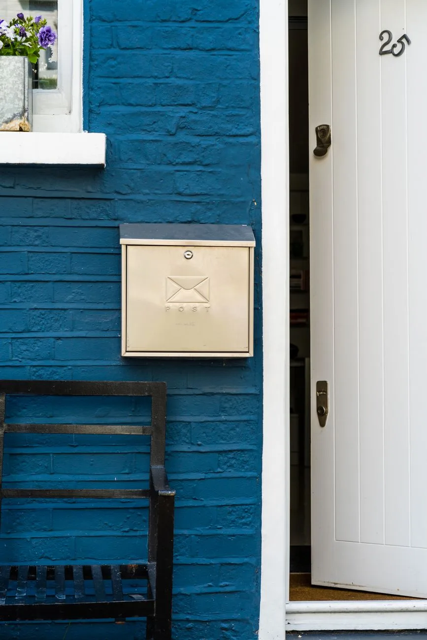 A welcoming home entrance with a blue brick exterior and a metal mailbox.
