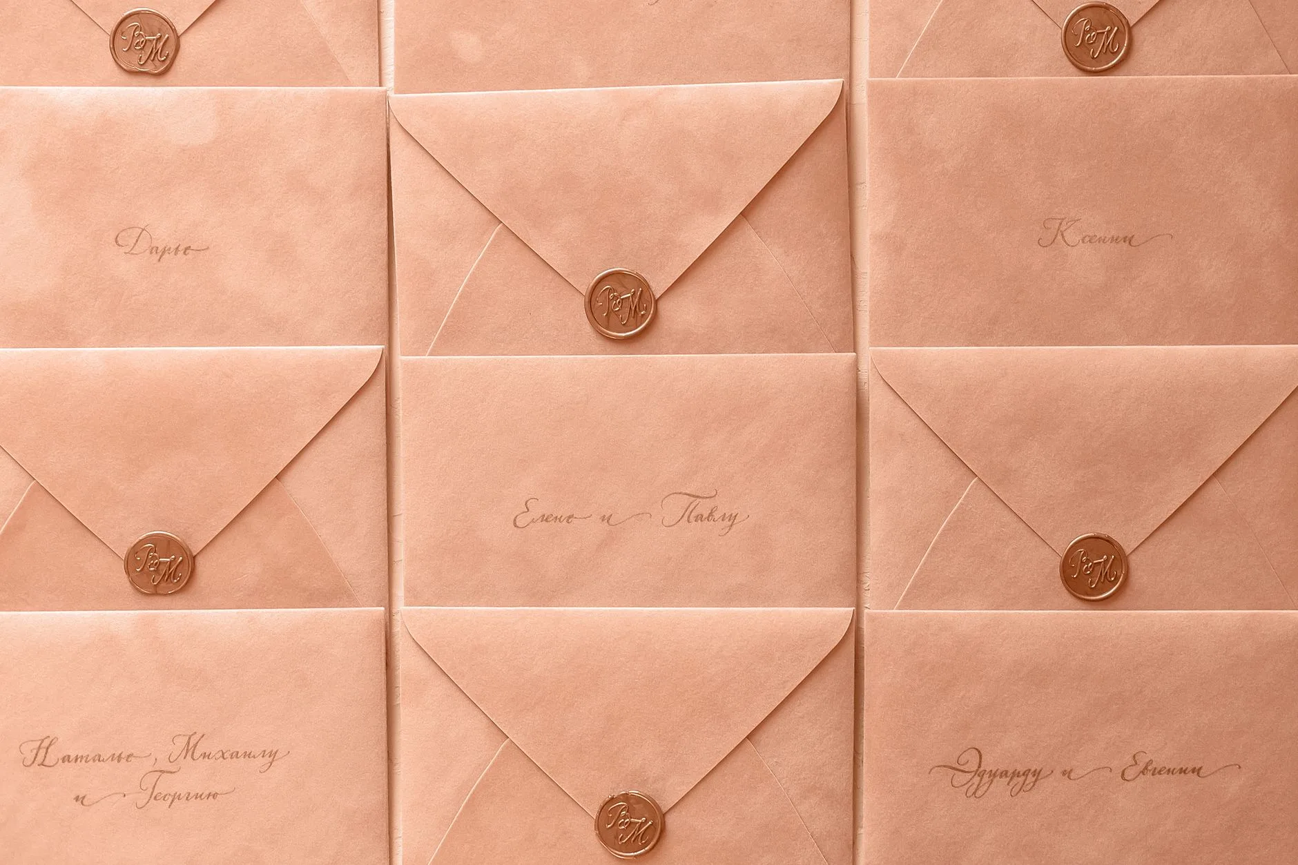 Rows of peach-colored envelopes sealed with wax and elegant calligraphy.